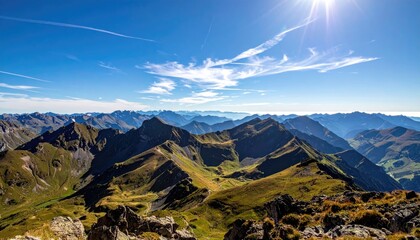 Panoramic mountain range under a bright sunny sky with dramatic clouds and lush green valleys below showcasing natural rugged terrain and vast wilderness scenery