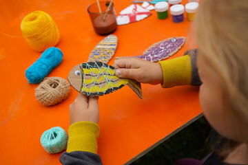 Design a fish figure from cardboard, thread, and paint, with detailed instructions, on an orange background.