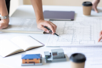 設計図とペンを持つ手