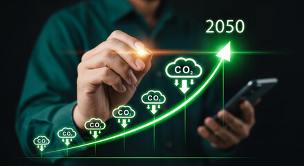 Carbon neutral economy growth graph showing falling CO2 icons along rising arrow to 2050 with hand holding light and smartphone in background evoking optimistic sustainable transition