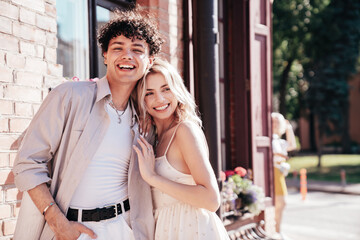 Smiling beautiful woman and her handsome boyfriend. Woman in casual summer clothes. Happy cheerful family. Female having fun. Couple posing in the street it sunny day