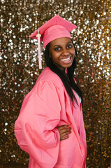 Smiling and happy teenage graduation black girl in cap and gown