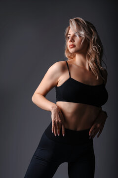 Portrait of a beautiful young blonde woman in black top sportswear
