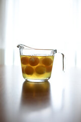 Glass measuring cup full of raw eggs sits on wooden table