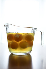 Glass measuring cup full of raw eggs sits on wooden table