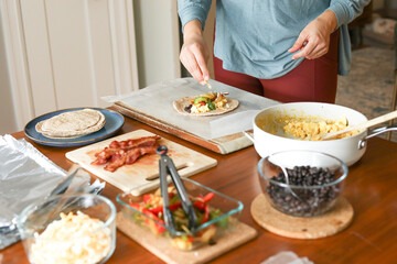 Woman in yoga top and pants sprinkles cheese for meal prep