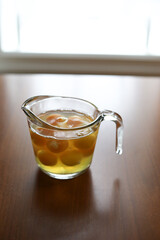 Glass measuring cup full of raw eggs sits on wooden table