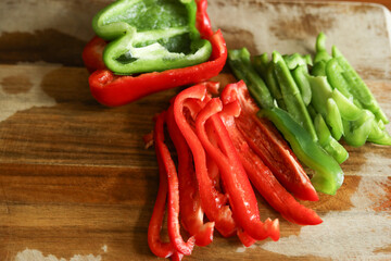 Red and Green peppers on wood cutting board