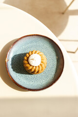 Mini bundt cake with cream on blue speckled plate