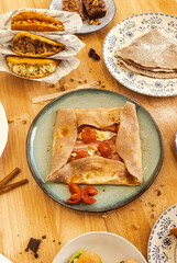 Brunch table offering savory crepes, arepas, and sweet desserts