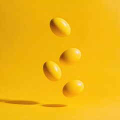 Four bright yellow eggs in mid-air against a vibrant yellow background