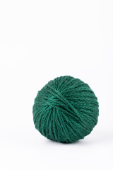 Green yarn ball with soft texture, vertical image on white background, minimalist style with copy space. Concept of diy projects and mindful creation