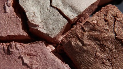 Close-up of broken shimmering cosmetic powder in earthy tones revealing textured surfaces and irregular cracks - Powered by Adobe