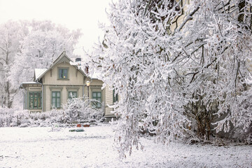 Wooden house in a park a cold winter day with hoarfrost on the trees