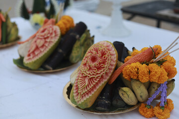 Serene offering of traditional Thai fruit carving for cultural ceremony. This beautiful display...