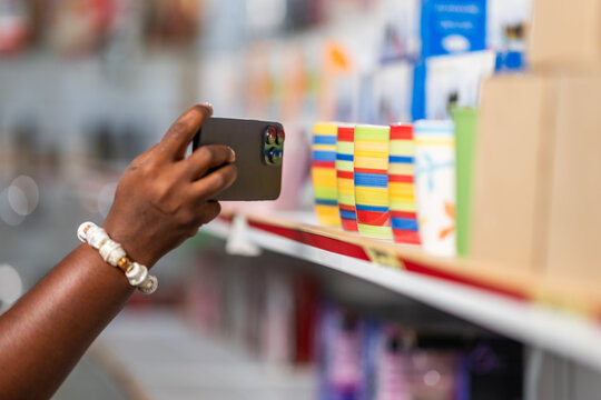 African businesswoman captures product photos with her smartphone in her supermarket for online marketing on social media
