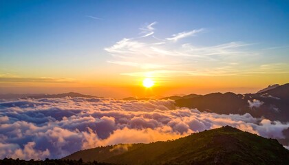 Aerial view of a mountain range at sunrise, clouds below