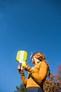 Woman playing pickleball in autumn