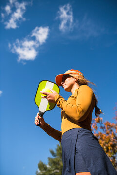 Woman playing pickleball in autumn