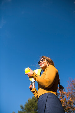 Woman playing pickleball in autumn