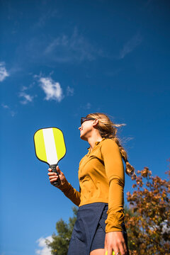 Woman playing pickleball in autumn