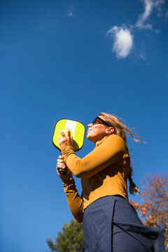 Woman playing pickleball in autumn