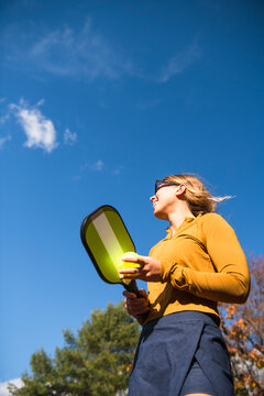 Woman playing pickleball in autumn