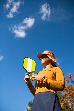 Woman playing pickleball in autumn