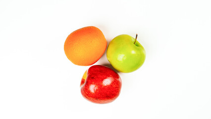 Fresh green apple, orange, and red apple arranged on a white background, showing vibrant color contrast for healthy lifestyle concept