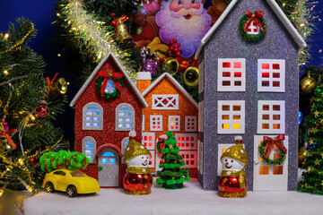 In the Christmas village, colorful decorated houses are surrounded by Christmas trees and snowmen