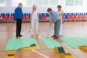 elderly group  plays mini golf for competitions in the sprot hall.  Kidult gaming in the gym....