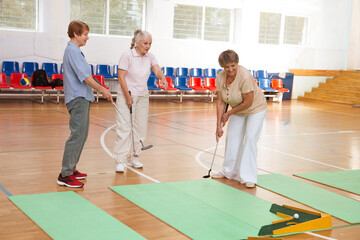 elderly group  plays mini golf for competitions in the sprot hall.  Kidult gaming in the gym....