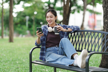 Young woman enjoying leisure time with smartphone in park