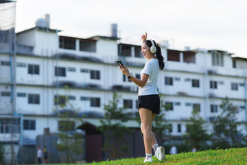 Young woman enjoying music with headphones in park