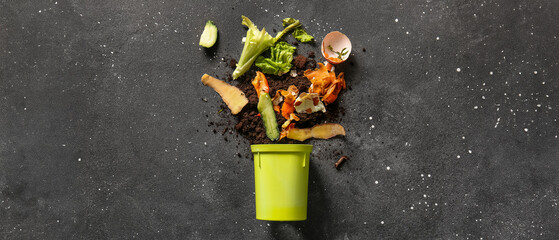 Bin with organic waste and soil on grey grunge background. Compost recycling concept