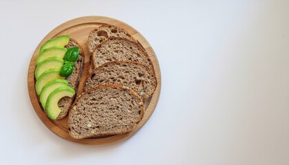 Modern flat lay of sliced multigrain bread with avocado slices and basil on a wooden plate. Clean white background and balanced lighting for a minimalist, health-conscious food aesthetic.