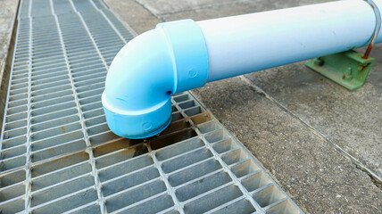 Large PVC pipe connected from the building roof to channel rainwater into the drainage system,