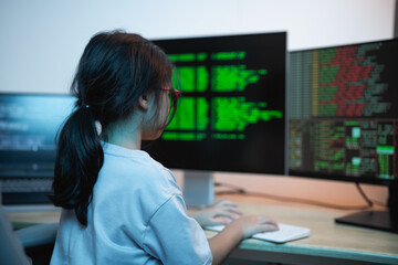 Child Engaged in Computer Programming with Multiple Monitors Displaying Coding Data and Tech...