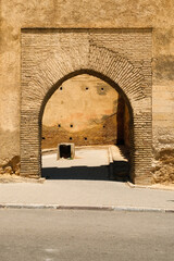 Traditional brick arch gateway leading to the old medina of Fes, Morocco, capturing the charm of historic Moroccan architecture.