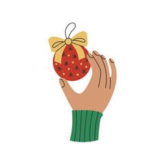 Human Hand Gesture with Christmas Bauble. Person Wrist in Knitted Sweater Sleeve Holding in Fingers Xmas Ornament Ball with Golden Bow Ribbon. Flat vector illustration