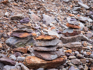 Stacked stone cairns made from mining rocks on a spoil heap in Špania Dolina, symbol of trail and balance in a former copper mining area.