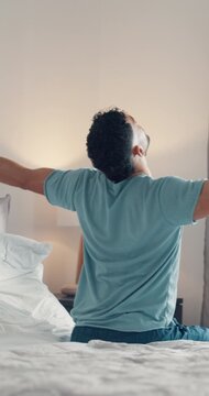 Back, stretching and wake up with man in bedroom of home for start of day or morning on weekend. Awake, relaxed and rested with person on bed in apartment for cozy comfort, me time or recovery