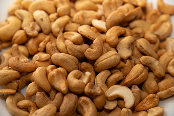 Cashews on a plate, top view. Loose cashews, close-up. Healthy eating concept.