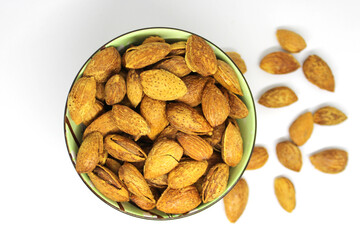 a close-up of roasted almonds in a small bowl, showcasing their golden-brown color and natural texture on white background