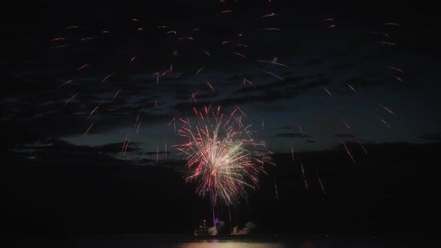 Abstract shot of exploding fireworks above the lake at night. Long exposure. 