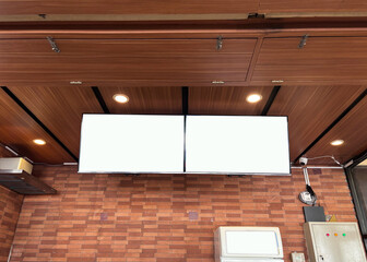 Blank white sign hangs from ceiling in modern interior, ready for branding or advertising message, creating a clean and professional atmosphere.