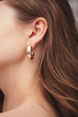 beautiful gold earring on a woman's ear