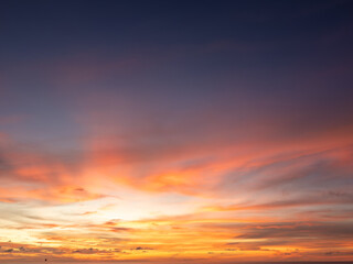 Vibrant sunset hues paint the horizon with fiery oranges, deep purples, and golden light, creating a breathtaking and dramatic atmospheric display. A tranquil end to the day.