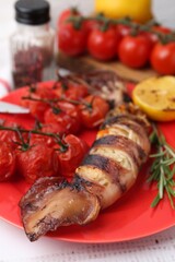 Tasty stuffed squid, rosemary and tomatoes on light wooden table, closeup