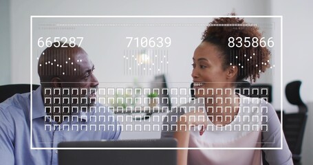 Analyzing colleagues in business attire discussing data at office desk with laptop, digital overlay